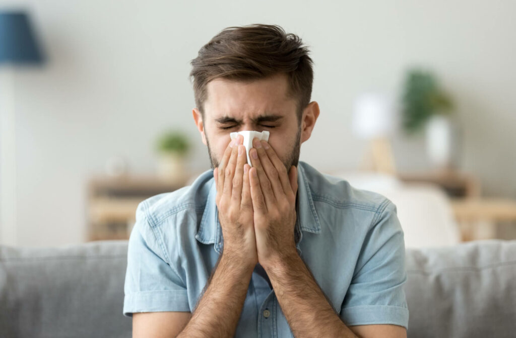 A man with allergies blowing his nose into a handkerchief.
