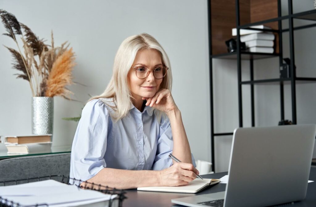 A person sitting comfortably at their computer after adjusting their workspace to reduce eye strain
