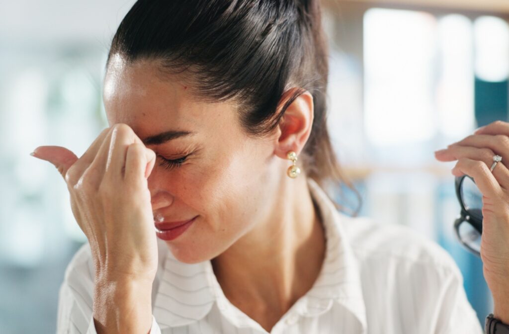 A person rubbing their eyes that are experiencing a pressure behind them