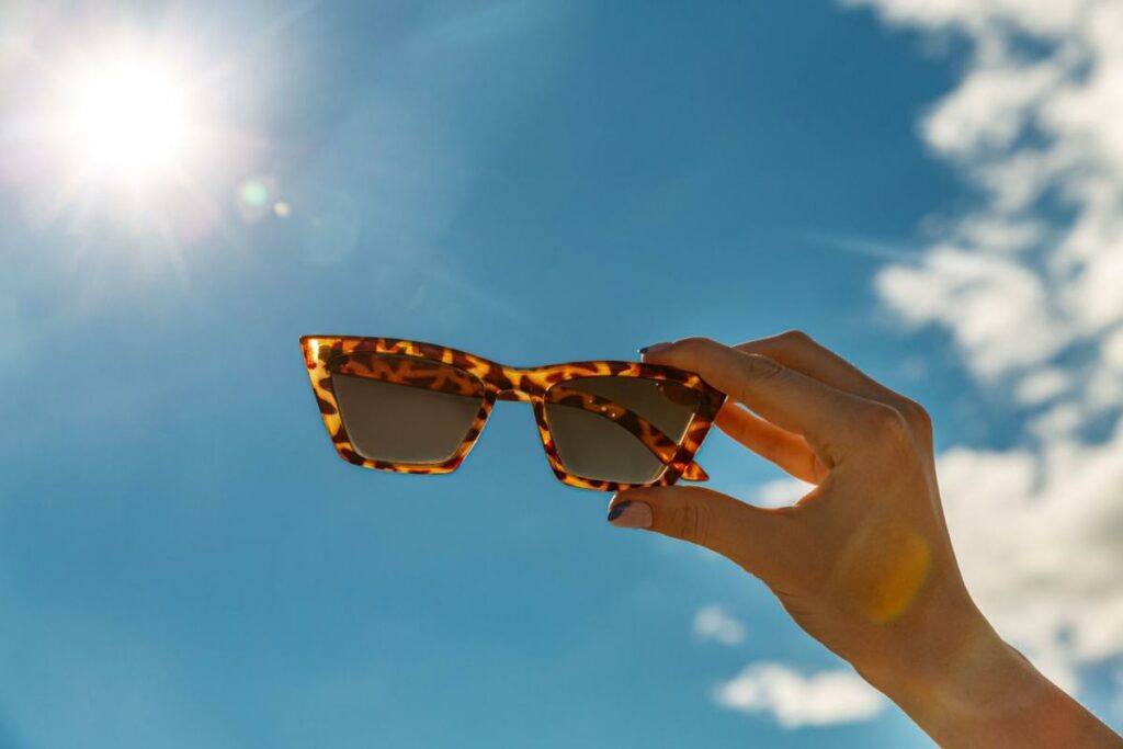 A pair of sunglasses being shown against the blue sky