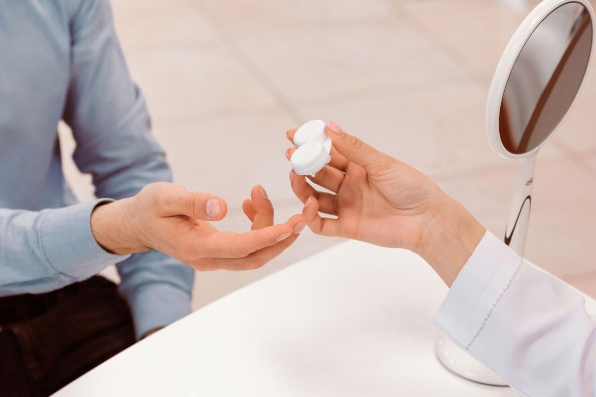 A person being handed a contact lens case